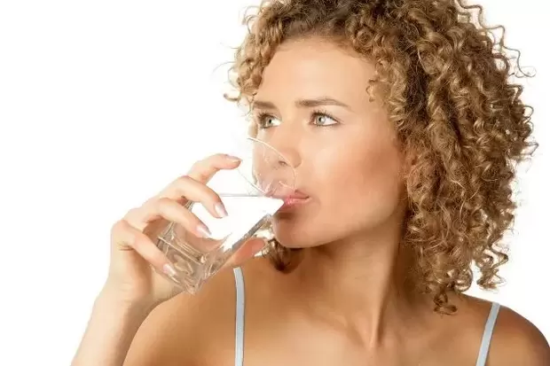 Момичето спазва диета за мързеливи, като преди хранене пие чаша вода